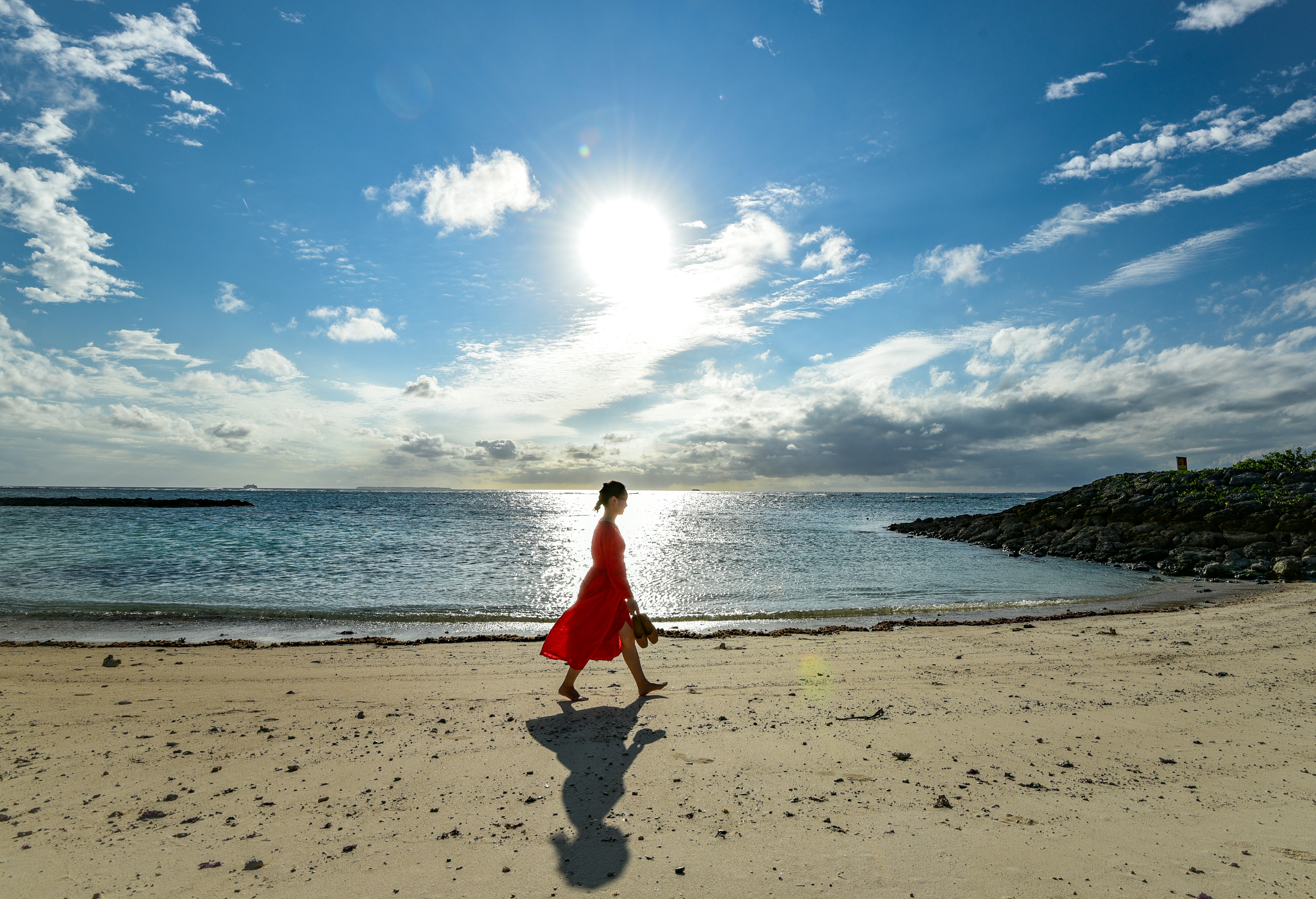 boy in red shirt walking on beach during daytime